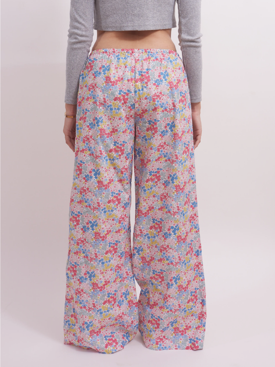 Back view of low-rise wide leg lounge pants in pastel pink ditsy floral print, showing a relaxed fit perfect for lounging or sleepwear. Made from 100% cotton for breathable comfort.