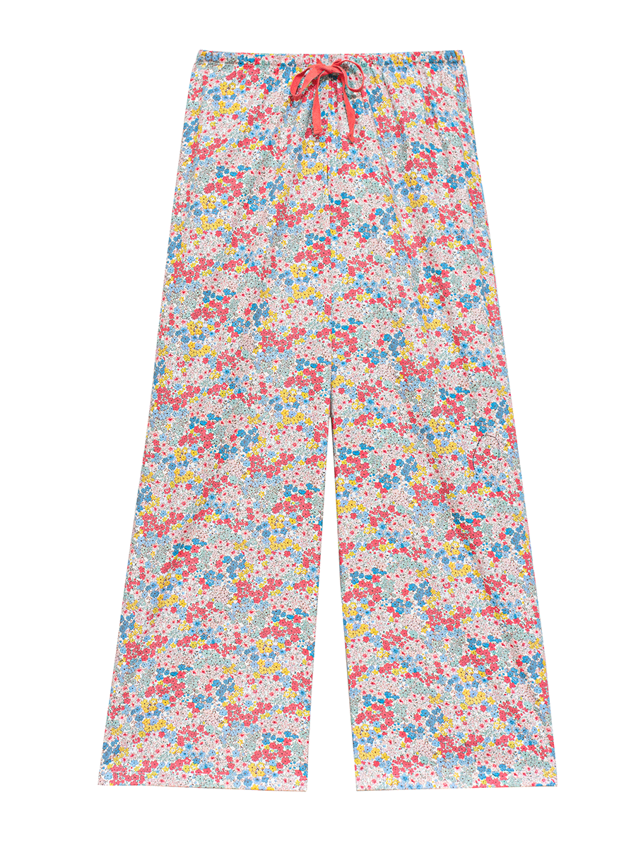 Full-length view of low-rise wide leg lounge pants in pastel pink ditsy floral print. These 100% cotton pants feature a red drawstring and relaxed fit, ideal for lounging or sleepwear.