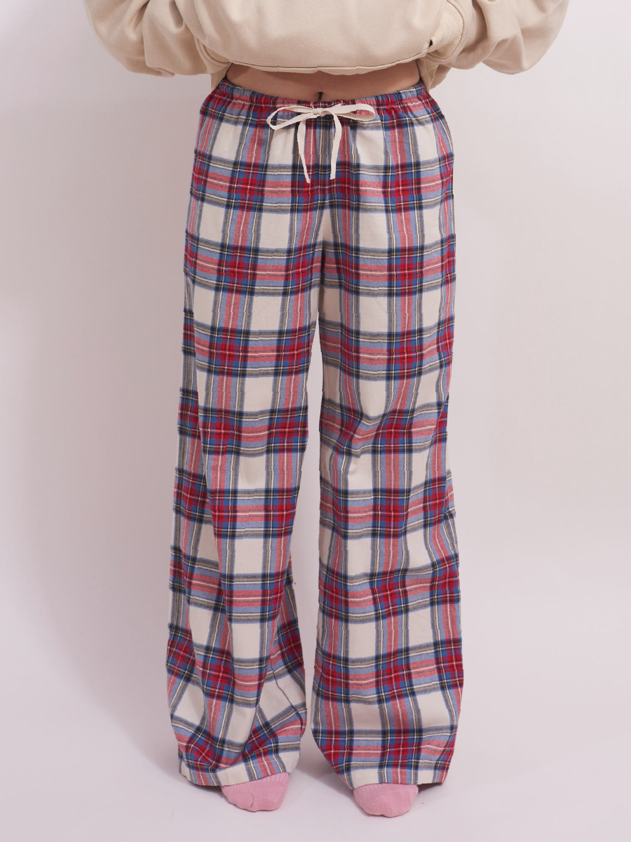 Full front view of low-rise wide leg lounge pants in red and cream plaid tartan, made from soft, brushed cotton flannel, perfect for cool weather lounging or as cozy pyjama bottoms.