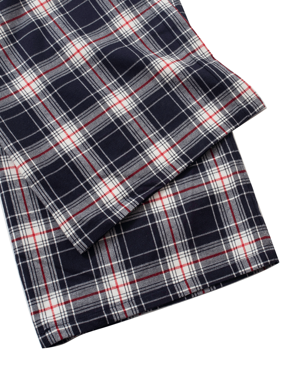 Hem detail of low-rise wide leg lounge pants in deep navy and rich red plaid tartan, crafted from 100% brushed cotton flannel, showing the clean edge and cozy fabric texture.