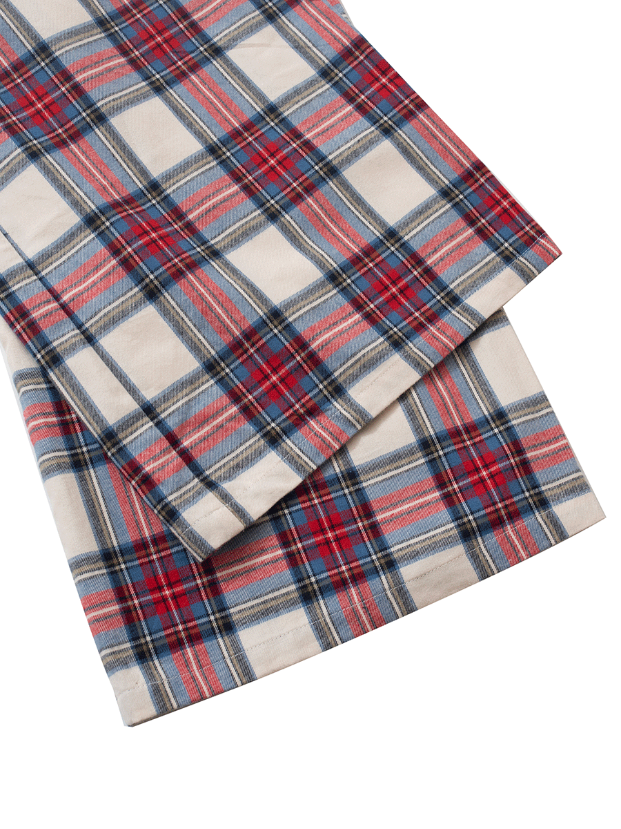 Hem detail of low-rise wide leg lounge pants in red and cream plaid tartan, crafted from soft brushed cotton flannel for a comfortable fit in cool weather.
