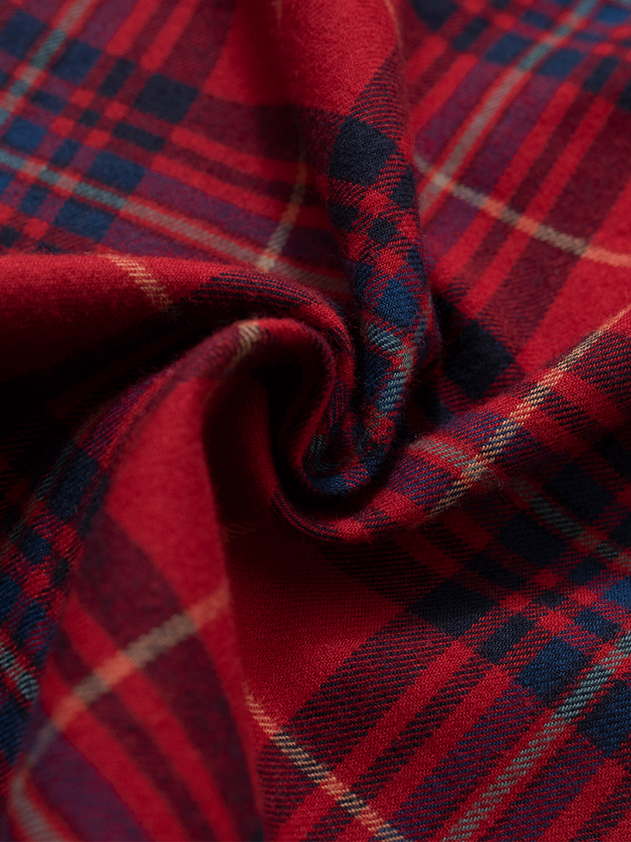 Close-up of red tartan brushed cotton fabric texture for winter pyjama pants.