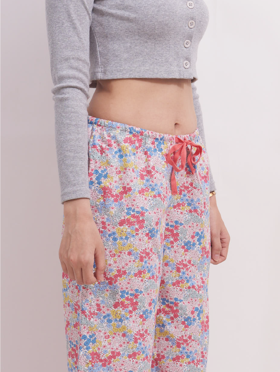 Close-up of the waistband on low-rise wide leg lounge pants in pastel pink ditsy floral print, featuring an adjustable red drawstring for a comfortable fit. Made from soft, breathable 100% cotton.
