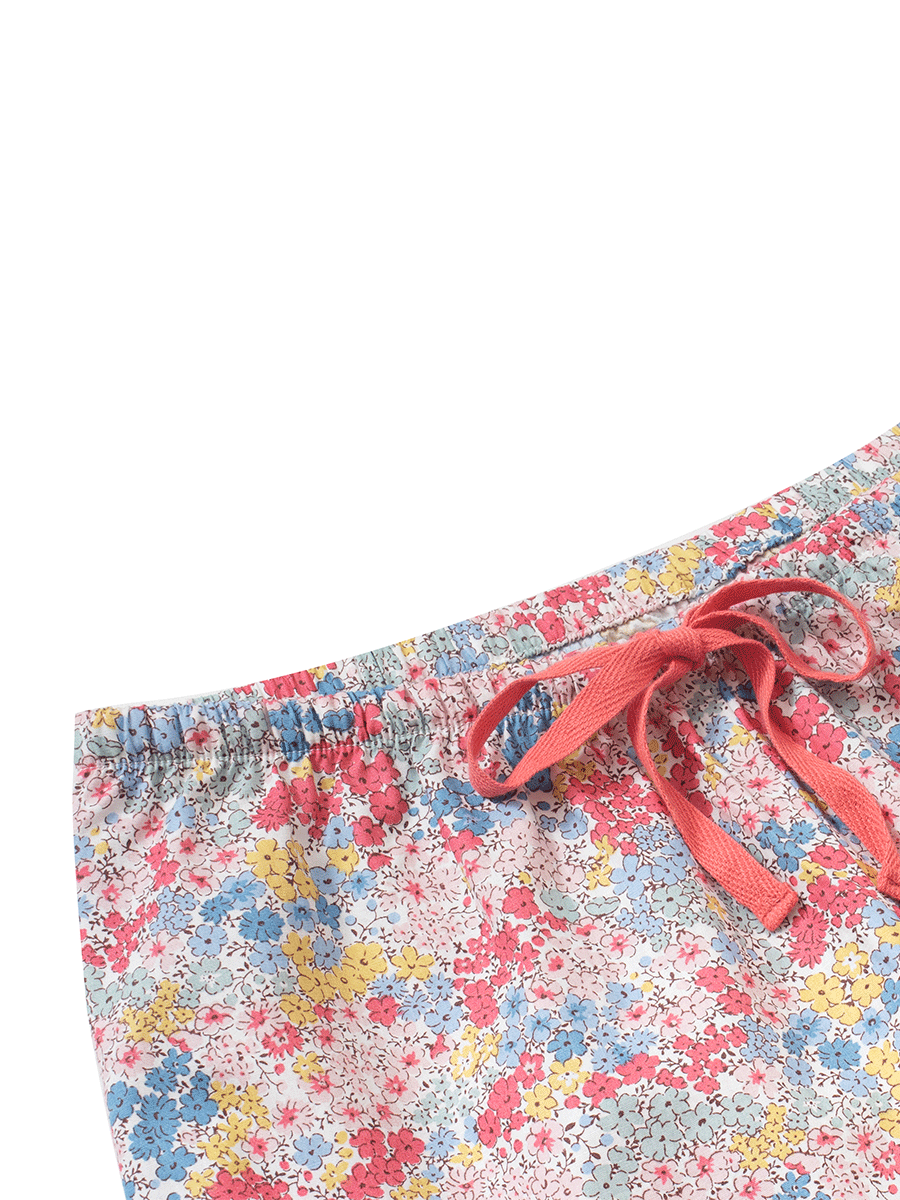Close-up of the waistband and red drawstring on low-rise wide leg lounge pants in pastel pink ditsy floral print, crafted from soft 100% cotton for a comfortable fit.