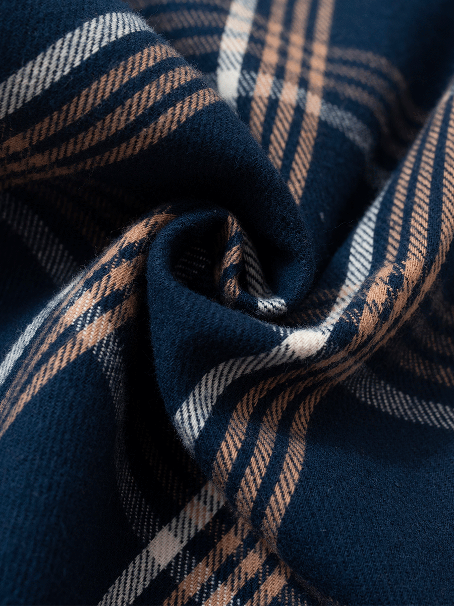 Detail of blue plaid tartan brushed cotton pyjama fabric, warm and 100% cotton.