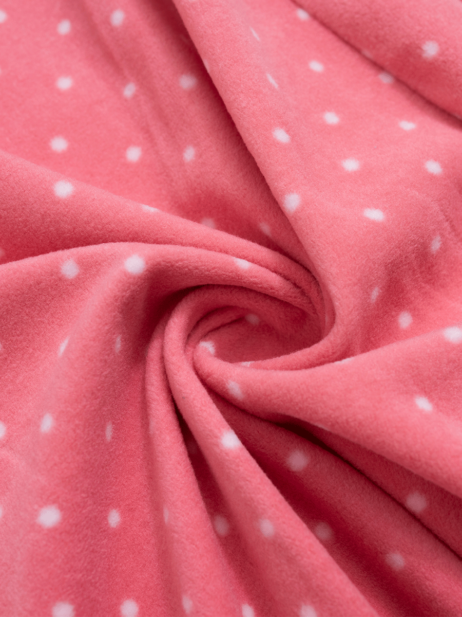 Close-up of soft, fuzzy pink polka dot fleece fabric, cosy for winter.